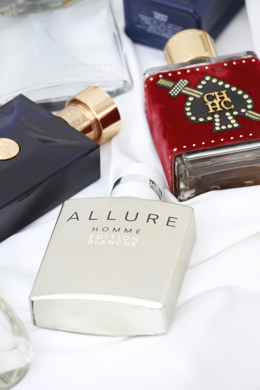 a table topped with bottles of different types of perfumes