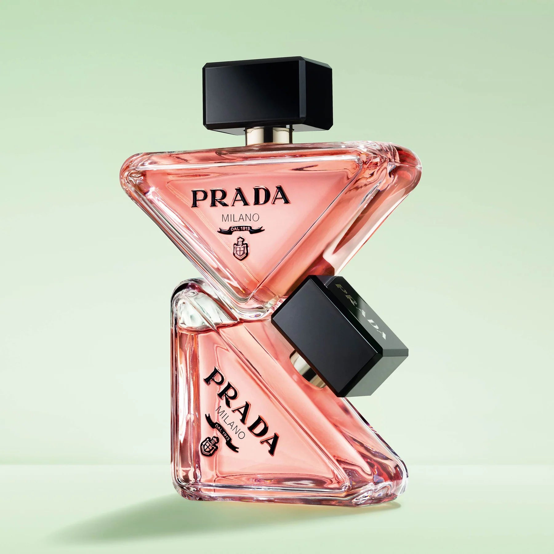 Prada perfume bottle on a light green background