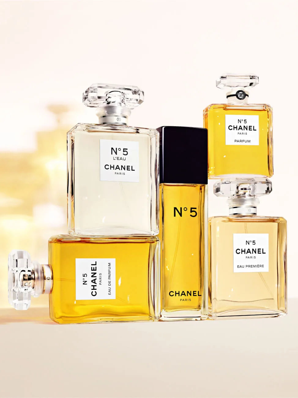 Chanel perfume bottles of various sizes on a light background