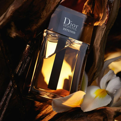 Dior Homme Intense perfume bottle with flowers on a dark background
