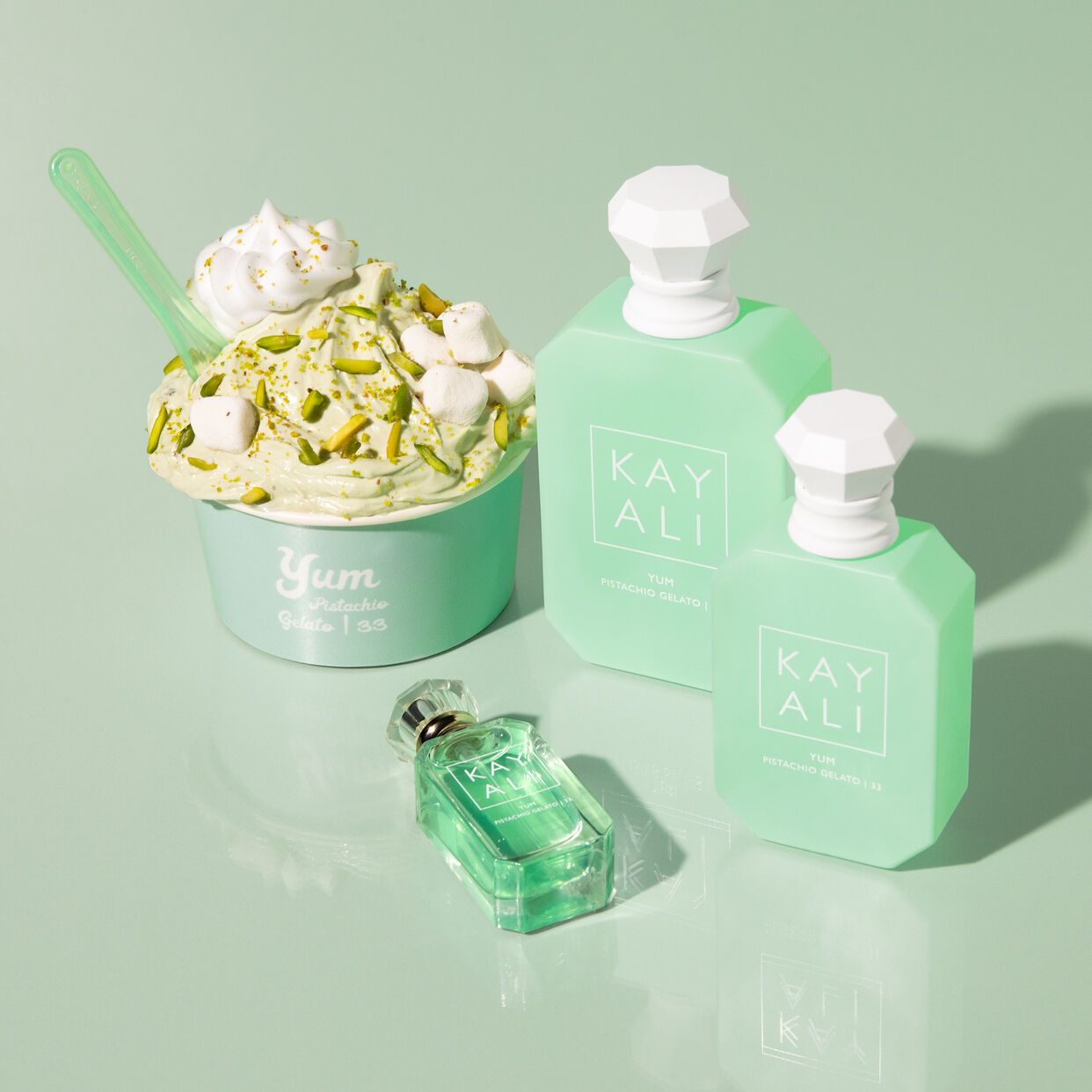 Green ice cream and KAYALI perfume bottles on a light green background