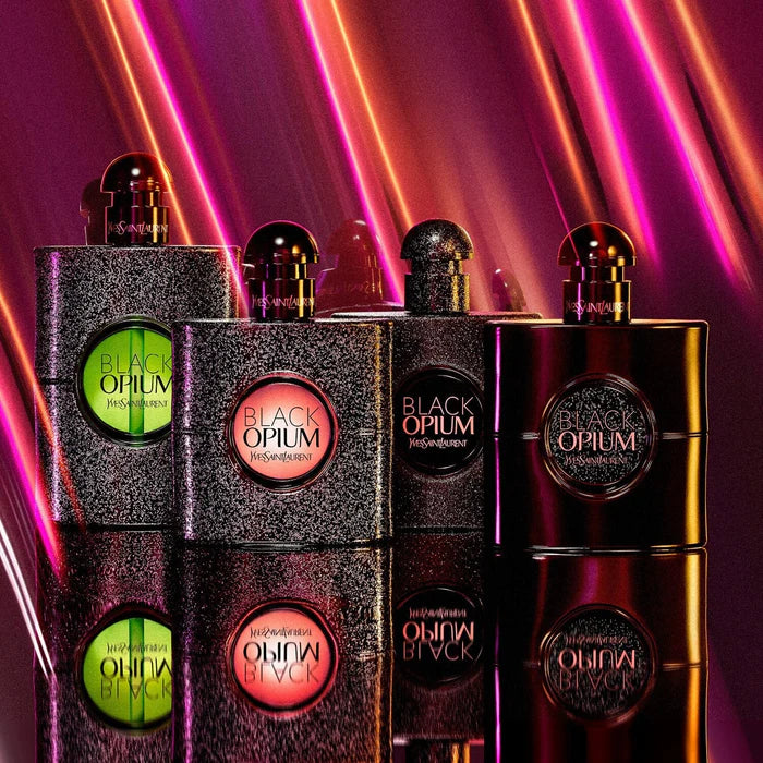 YSL Black Opium perfume bottles with colorful lights on a reflective surface
